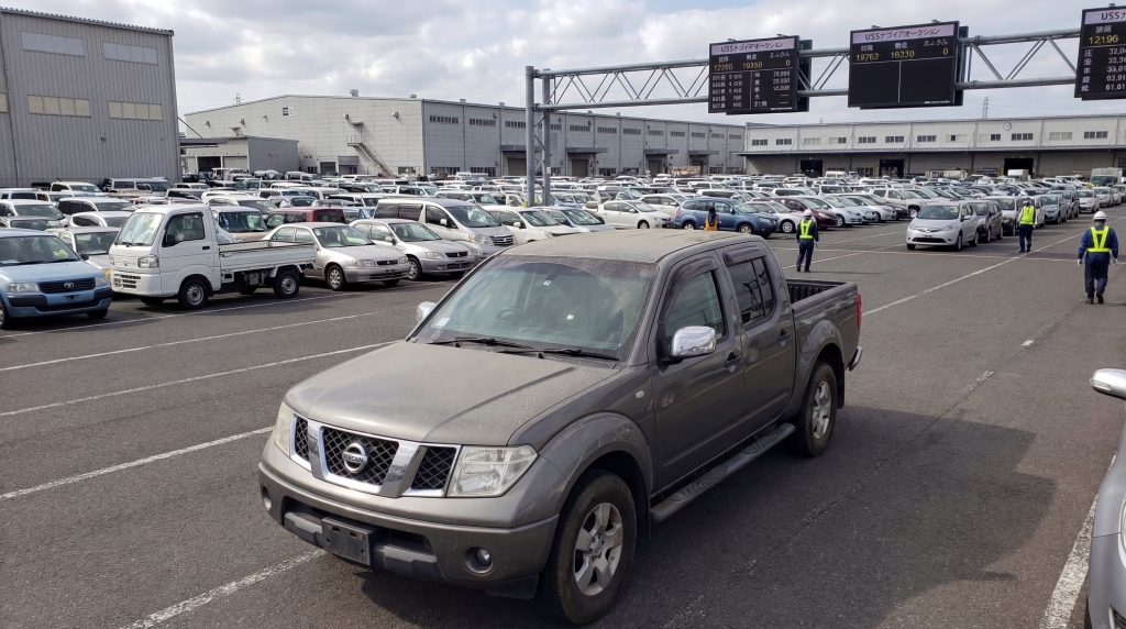 japanese-car-auction-process-6 Used pickup truck driving through the Japanese auto auction yard with thousands of cars